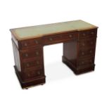 A late Victorian mahogany inverted breakfront pedestal desk