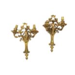 A pair of early 20th Century French gilt metal twin branch wall lights in the French Empire taste