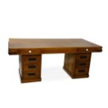 A large Art Deco oak desk, the rectangular top with ebonised wood trim