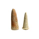 TWO CUNEIFORM CLAY FOUNDATION CONES Including a cone inscribed in two columns of text, identifying