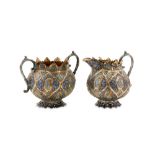 An early 20th century Anglo – Indian Raj unmarked silver parcel gilt and enamel milk jug and twin ha