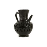 A BLACK-GLAZED PIERCED POTTERY EWER