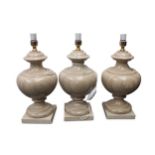 A set of three beige marble table lamp bases