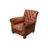 An early 20th century tan leather upholstered button back arm chair