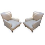 A pair of cream upholstered easy arm chairs