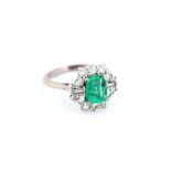 An emerald and diamond cluster ring