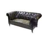 An Edwardian Chesterfield sofa upholstered in black leather