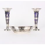 A pair of silver vases, S & H, Birmingham 1907, of flared, pierced form with blue glass liners,