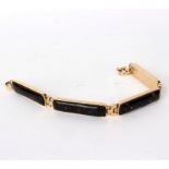 A 9ct gold bracelet, the four elongated rectangular links set with dark panels,