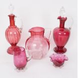 Two cranberry glass decanters and stoppers each of baluster form with clear reeded handle,