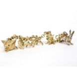 An 18ct gold bracelet hung with three 14ct gold charms of a fox, a horse and a hound,