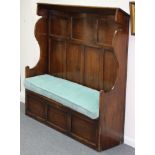 An elm settle with hooded canopy, panel back and box seat with loose seat cushions,