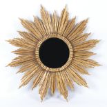 A modern carved and gilded starburst mirror with bevelled plate,