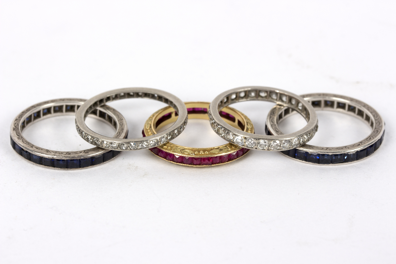 A diamond eternity ring set in precious white metal, size P½, another similar (lacking a stone),