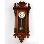 A walnut cased Vienna style regulator, the white enamel dial with Roman numerals,