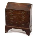 A small oak bureau with four drawers on bracket feet,