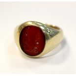 A 9ct gold signet ring set with a carved cornelian matrix, crested,
