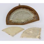 A carved ivory brisé fan with pierced stylised design and end sticks,