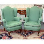 A pair of wing back upholstered armchairs,