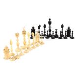 An early 19th Century natural and black stained ivory part chess set with intricately pierced and