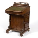 A Victorian walnut Davenport with stationery compartment to the back,