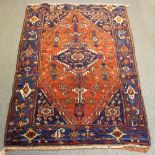 An Eastern rug with central medallion to a red ground,