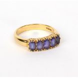 A five-stone ring set in 18ct yellow gold, the pale blue stones in a scroll setting, size O,