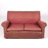 An upholstered two-seater sofa covered in pink damask,