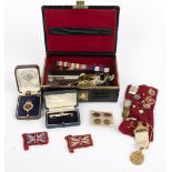 A small jewel case containing enamelled badges of equestrian interest, shirt studs, stick pins, etc.