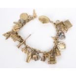 A 9ct gold bracelet hung with numerous mainly 9ct charms,