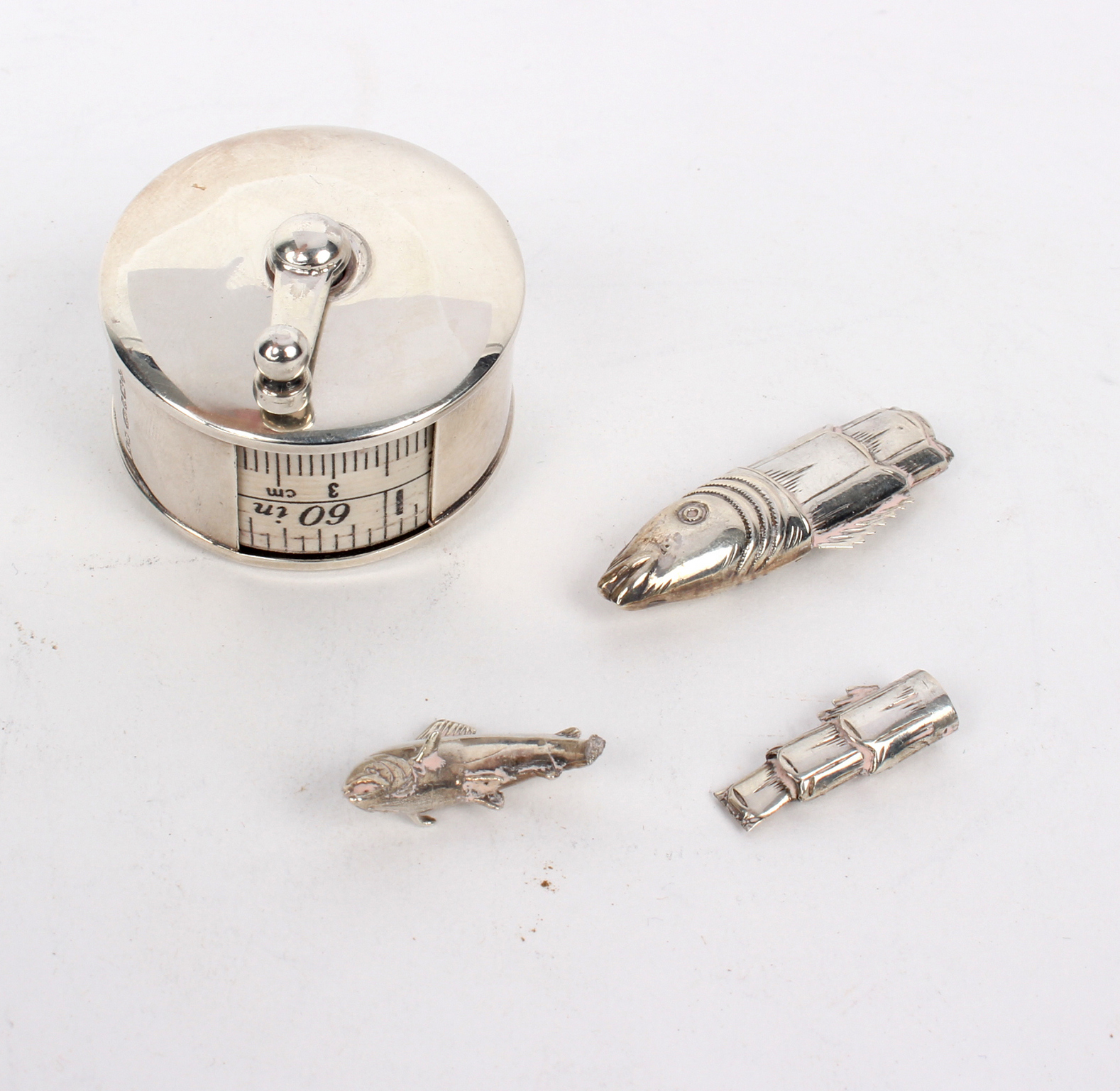 A novelty silver cased tape measure, WW, Birmingham 2000, of fishing reel form,