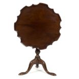 A George III mahogany tripod table, with pie-crust border on a turned and reeded column,