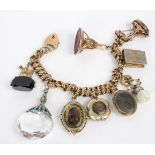 A 9ct gold fancy link bracelet hung with pendants, lockets and seal fobs,