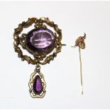 A stick pin with bull's head terminal and a Victorian brooch with purple stone and drop