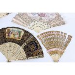 A 19th Century fan with pierced ivory sticks and printed scenes of figures in a garden landscape,