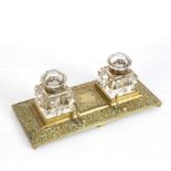 A brass inkstand, fitted two cut glass inkwells and a pen stand,
