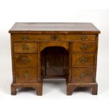 A George I style walnut veneered kneehole desk with herringbone banding throughout,