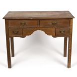 An oak lowboy fitted four drawers above a shaped apron on square legs,