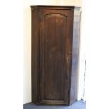 A George III oak floor standing corner cupboard,