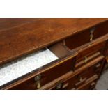 A 17th Century oak chest of four drawers with geometric moulded drawer fronts and brass bell drop