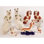 A pair of pearlware figures of seated cats with sponged patches in yellow, black and brown,