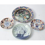 A famille rose plate decorated scenes of peacocks together with a pair of Imari plates and a Fukien