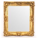 A Victorian gilt-framed mirror with shell and scroll frame