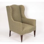 A Victorian wing back armchair on square taper legs with castors