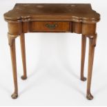 A George III mahogany fold-over games table, the baize lined interior with guinea wells,
