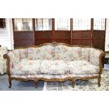 A carved beech settee on cabriole legs with floral upholstery, 220cm wide,