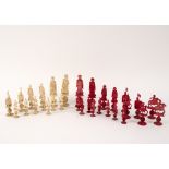 A near complete set of carved and red stained ivory chess pieces,