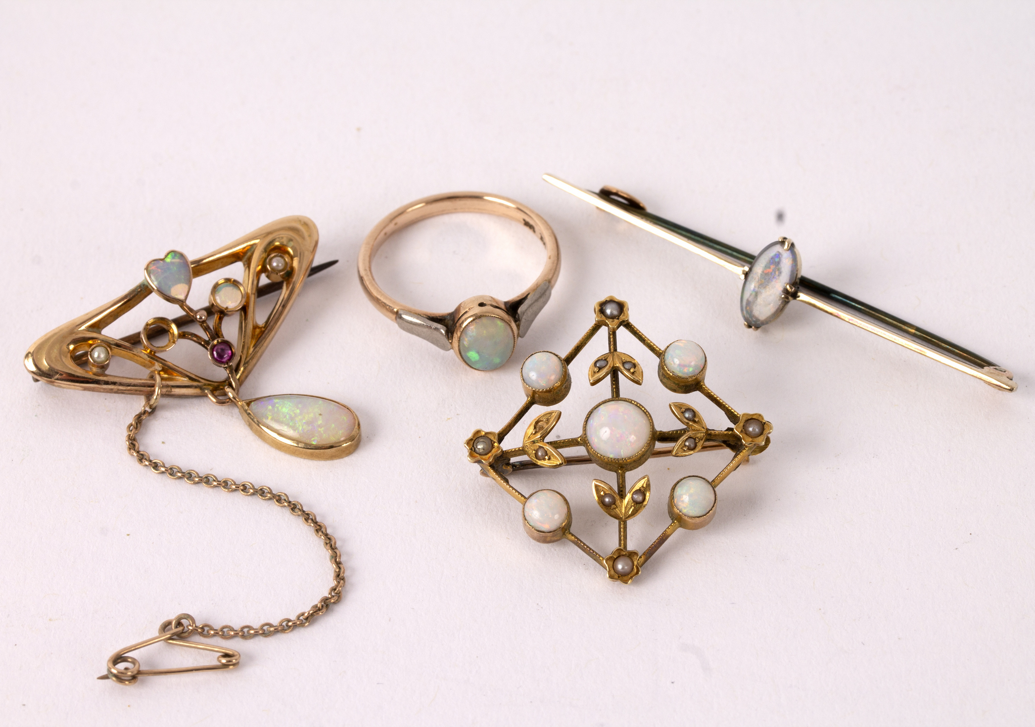 A group of opal set jewellery comprising an Art Nouveau brooch, another of square form,