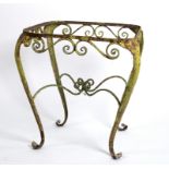 A cast iron garden side table with cabriole legs and scroll decoration, 54cm tall,