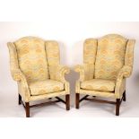 A pair of George III style wing back armchairs,